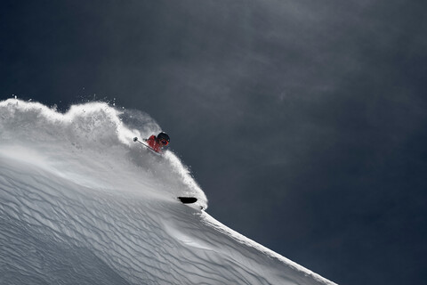 Männlicher Skifahrer, der einen steilen Berghang hinunterfährt, Alpe-d'Huez, Rhone-Alpes, Frankreich, lizenzfreies Stockfoto