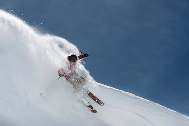 Male skier skiing down steep mountainside, Alpe-d'Huez, Rhone-Alpes, France - CUF49671