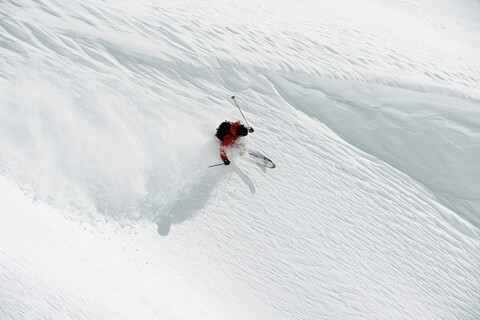 Männlicher Skifahrer, der einen Berghang hinunterfährt, Blick von oben, Alpe-d'Huez, Rhone-Alpes, Frankreich, lizenzfreies Stockfoto