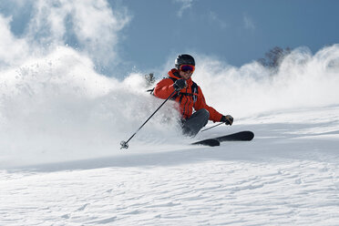 Male skier skiing down mountainside, low angle view, Alpe-d'Huez, Rhone-Alpes, France - CUF49680