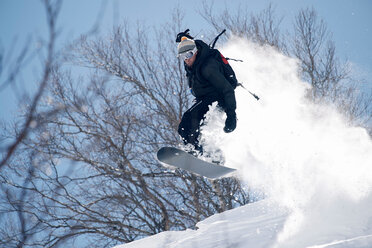 Männlicher Snowboarder beim Snowboarden in der Luft am Berghang, Alpe-d'Huez, Rhone-Alpes, Frankreich - CUF49692
