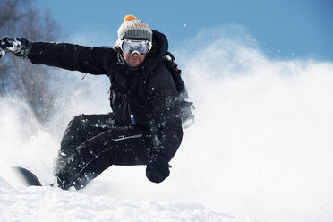 Männlicher Snowboarder, der einen Berghang hinunterfährt, Alpe-d'Huez, Rhone-Alpes, Frankreich - CUF49694