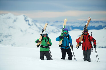 Landschaft mit drei männlichen Skifahrern, die Skier tragen, Porträt, Alpe-d'Huez, Rhone-Alpes, Frankreich - CUF49708