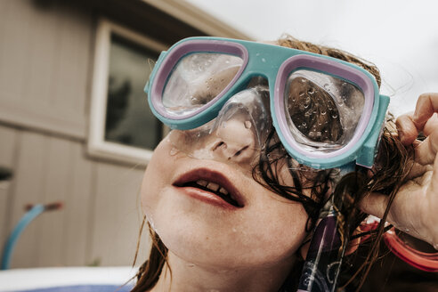 Nahaufnahme eines niedlichen Mädchens mit Schwimmbrille im Pool gegen den Himmel - CAVF63118