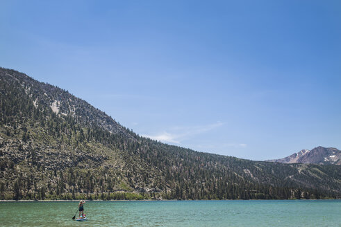 Mutter Paddleboarding mit Tochter in See gegen Berge und Himmel im Sommer - CAVF63121