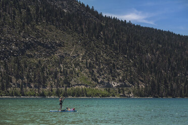 Mutter Paddleboarding mit Töchtern in See gegen Berge im Sommer - CAVF63122