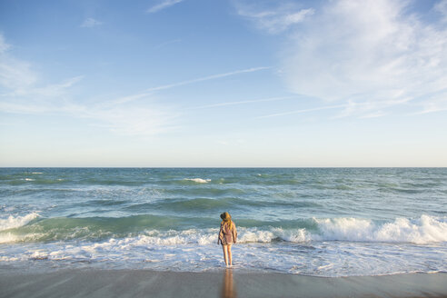 Rückansicht einer am Strand stehenden Frau gegen den Himmel bei Sonnenuntergang - CAVF63138