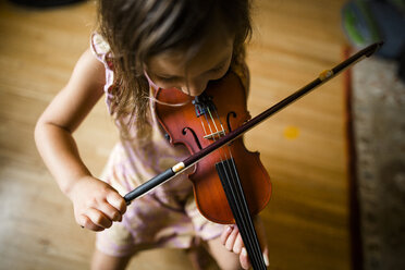 Hoher Blickwinkel eines Mädchens, das zu Hause sitzt und Geige spielt - CAVF63142