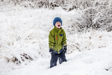 Ein weinender Junge steht auf einem verschneiten Feld - CAVF63149