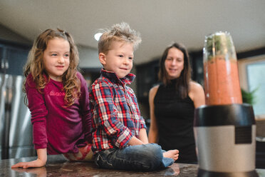 Mutter und Kinder beobachten Mixer bei der Herstellung eines Smoothies - ISF21010