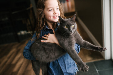 Little girl playing with cat at home - ISF21015