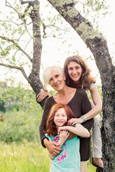 Mädchen am Gartenbaum mit Mutter und Großmutter, Porträt - ISF21050
