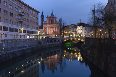 Slowenien, Ljubljana, Blick auf das Stadtzentrum mit Franziskanerkirche und beleuchteter Dreifachbrücke - FCF01731