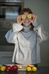 Lachendes Teenager-Mädchen, das sich Zitronenhälften vor die Augen hält - LBF02416