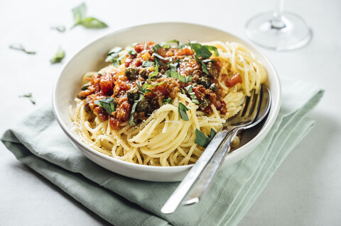 Spaghetti mit Tomaten-Kapernsauce, Basilikum und Parmesan, lizenzfreies Stockfoto