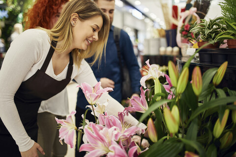 Verkäuferin berät Paar im Blumenladen, lizenzfreies Stockfoto