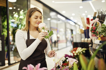 Florist riecht an Blume im Blumenladen - ZEDF01974