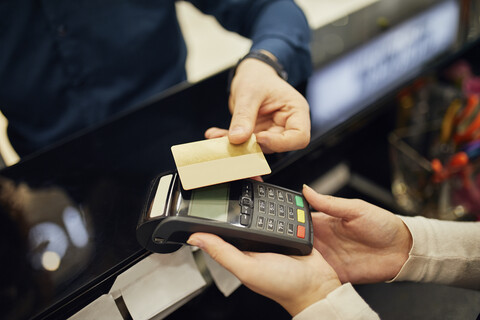 Nahaufnahme eines Kunden, der in einem Geschäft bargeldlos mit Kreditkarte bezahlt, lizenzfreies Stockfoto