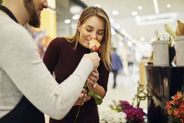 Florist lässt Kunde an Blume in Blumenladen riechen - ZEDF02005