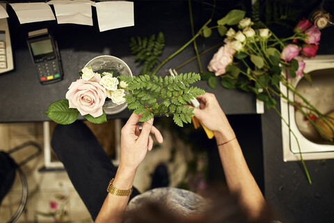 Nahaufnahme einer Floristin beim Arrangieren von Blumen in einem Blumenladen, lizenzfreies Stockfoto