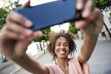Glückliche junge Frau macht ein Selfie in der Stadt - JSMF00864