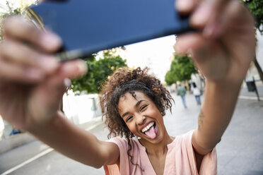 Unbekümmerte junge Frau macht ein Selfie in der Stadt - JSMF00865