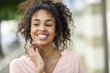 Portrait of smiling young woman in the city - JSMF00872