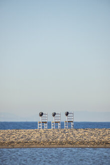 Drei leere Stühle mit Hüten nebeneinander vor dem Meer - KBF00593