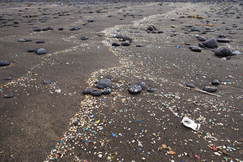 Spanien, Kanarische Inseln, Lanzarote, Playa Famara, Mikroplastik, angespült auf dunklem Lavasand - SIEF08424