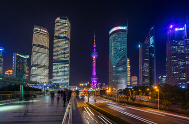 Pudong skyline and Oriental Pearl Tower from elevated walkway at night, Shanghai, China - CUF49848