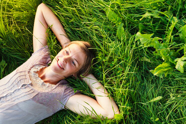 Woman lying down on grass in countryside - CUF49900