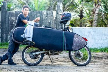 Motorradfahrer mit Surfbrett auf dem Fahrrad, Pagudpud, Ilocos Norte, Philippinen - CUF49909