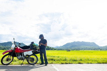 Motorradfahrer, der am Straßenrand anhält, Camalaniugan, Cagayan, Philippinen - CUF49910