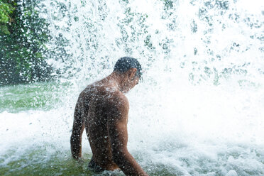 Mann unter erfrischendem Wasserfall - CUF49928