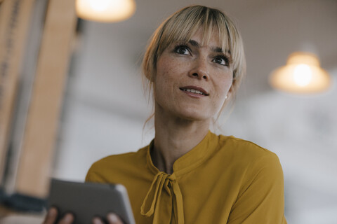 Porträt einer schönen blonden Frau, mit digitalem Tablet, lizenzfreies Stockfoto