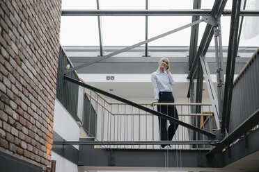 Businesswoman leaning on railing, talking on the phone - JOSF03185