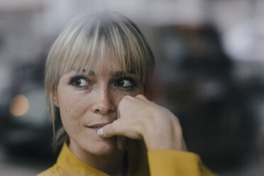 Blond businesswoman sitting at window, thinking - JOSF03196