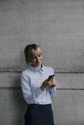 Blong businesswoman using smartphone, reading messages - JOSF03247