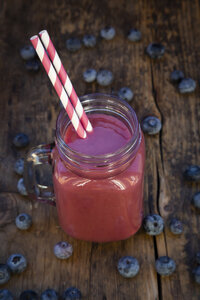 Blaubeer-Smoothie im Glas auf dunklem Holz - LVF07866