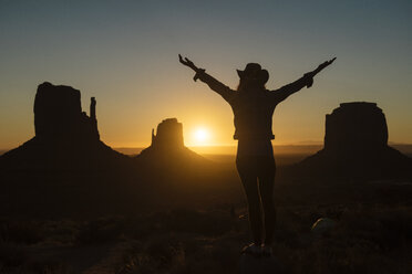 USA, Utah, Monument Valley, silhouette of happy woman with cowboy hat enjoying sunrise - GEMF02890