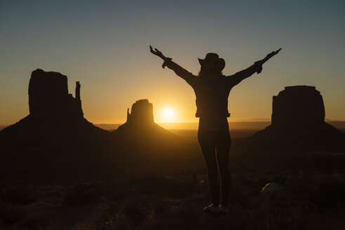 USA, Utah, Monument Valley, Silhouette einer glücklichen Frau mit Cowboy, die den Sonnenaufgang genießt - GEMF02890