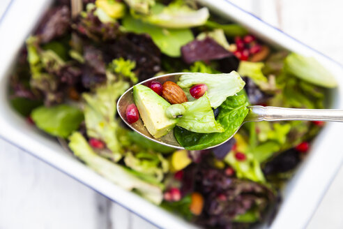 Detox-Salatschüssel mit Avocado, Granatapfelkernen, gerösteten Sojabohnen, Sonnenblumenkernen und Nüssen, auf Löffel - LVF07870