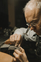 Kunsthandwerker bei der Herstellung von Schmuck in seiner Werkstatt - AHSF00006