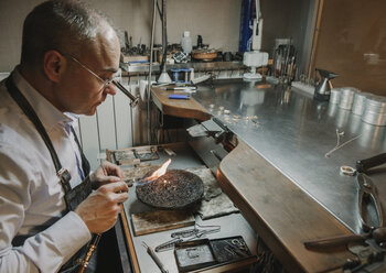 Kunsthandwerker bei der Herstellung von Schmuck in seiner Werkstatt - AHSF00013