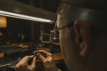 Kunsthandwerker bei der Herstellung von Schmuck in seiner Werkstatt - AHSF00025