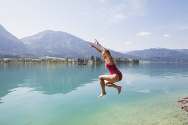 Austria, Alps, Salzburg, Salzkammergut, Salzburger Land, Wolfgangsee, woman jumping into lake - GWF06013