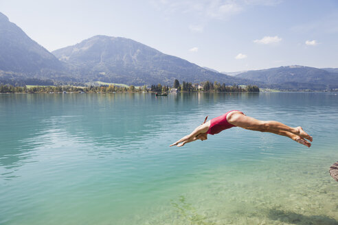 Austria, Alps, Salzburg, Salzkammergut, Salzburger Land, Wolfgangsee, woman jumping into lake - GWF06014