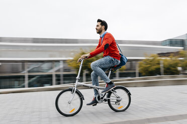 Geschäftsmann, der mit seinem Klapprad in der Stadt pendelt - JRFF02820