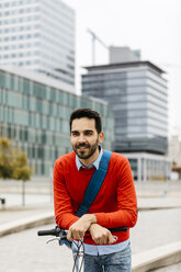 Casual businessman commuting in the city, using his folding bike - JRFF02822