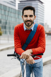 Geschäftsmann, der mit seinem Klapprad in der Stadt pendelt - JRFF02824